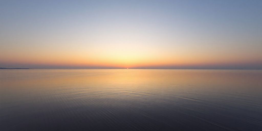Sunset over a tranquil lake with soft colors.